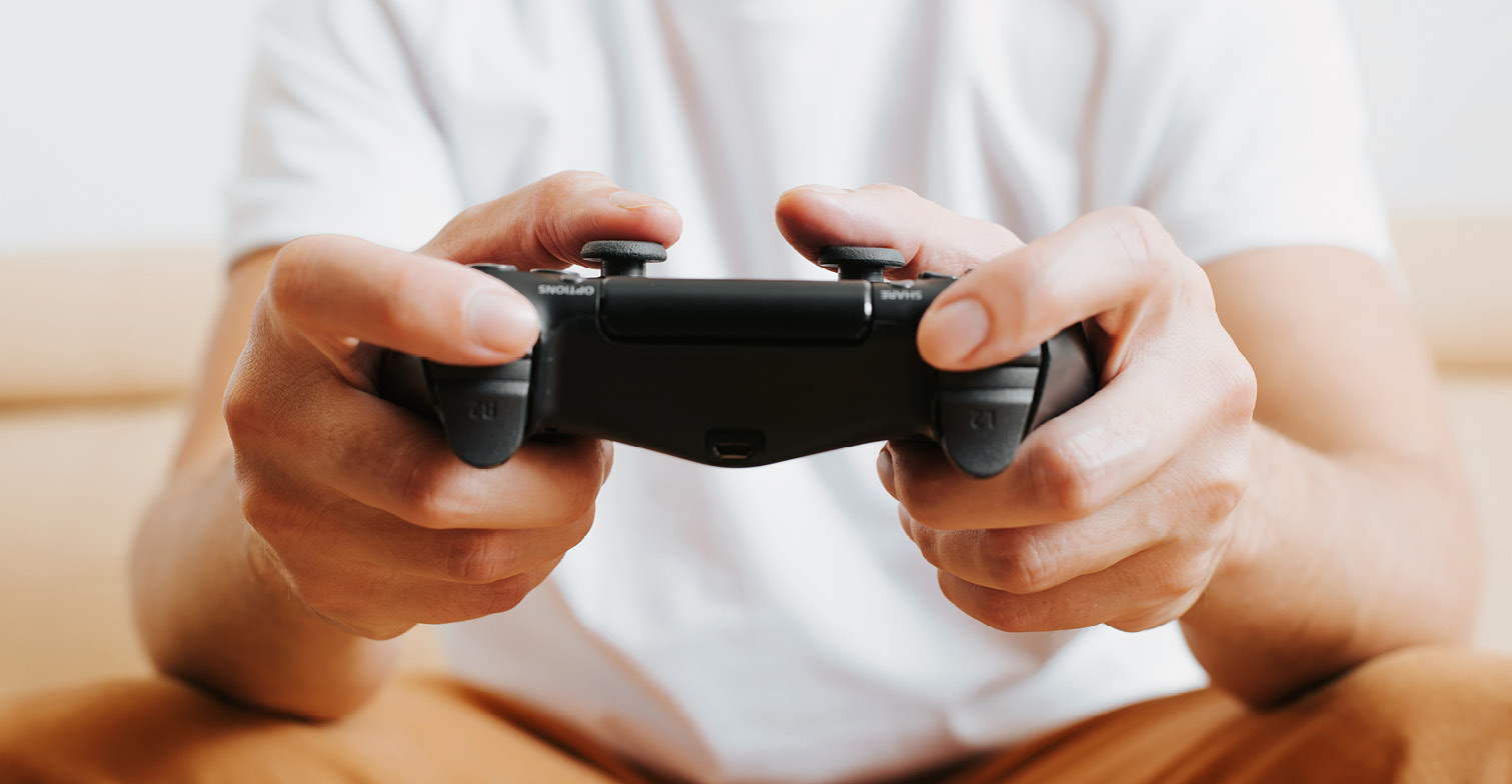 Detailaufnahme von den Händen einer Person, die einen Spielecontroller hält.