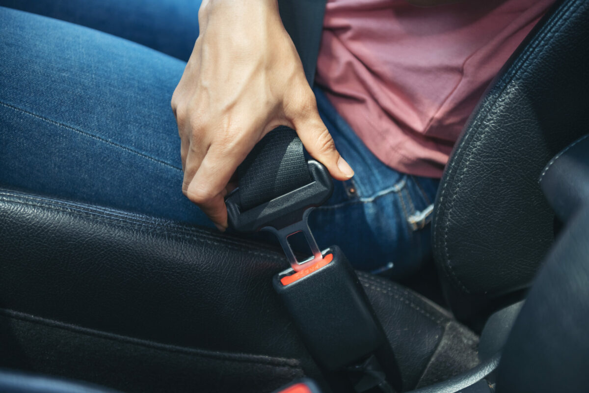 Sicherheitsgurt im Auto. Griff einer Frau zur Schnalle